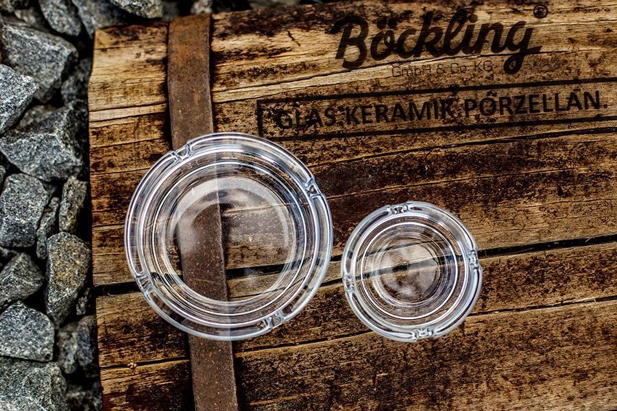 Two clear glass coasters on a rustic wooden box with the inscription 'Böckling'.